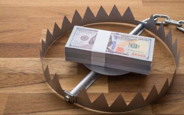 Pile Of Money Dollar Banknotes In Trap On Wooden Table Background.