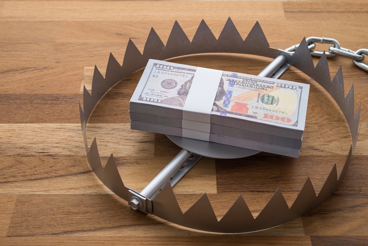Pile Of Money Dollar Banknotes In Trap On Wooden Table Background.